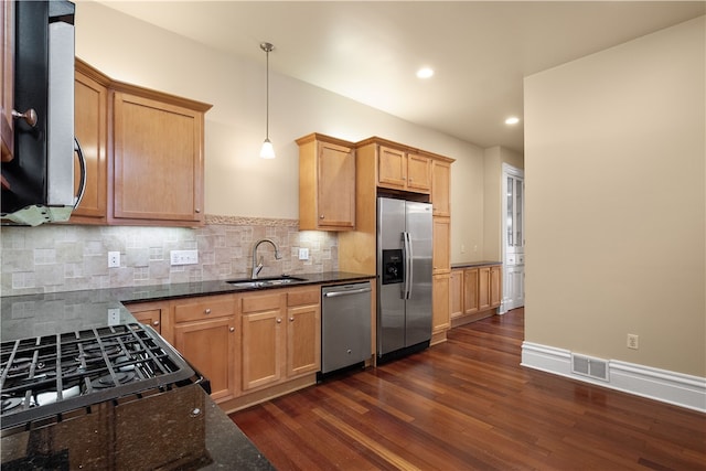 kitchen featuring pendant lighting, dark wood-type flooring, sink, tasteful backsplash, and stainless steel appliances