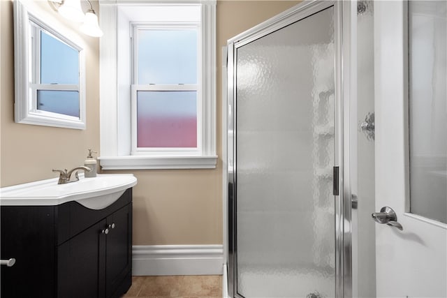 bathroom with tile patterned flooring, vanity, and walk in shower