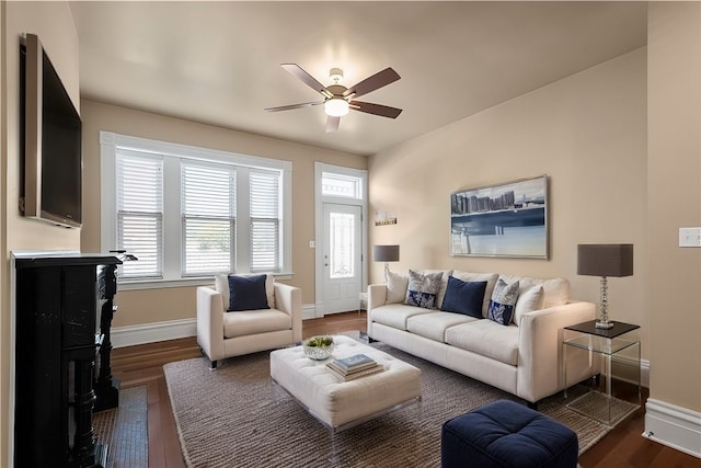 living room with ceiling fan and dark wood-type flooring