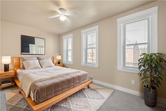 bedroom featuring multiple windows, ceiling fan, and carpet