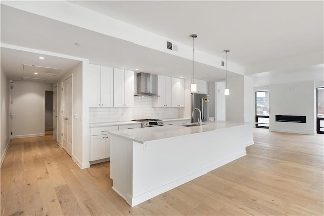 2330 Penn Ave Unit 302, Downtown Pgh, PA 15222 - kitchen featuring wall chimney exhaust hood, a sink, range, light wood finished floors, and white cabinetry