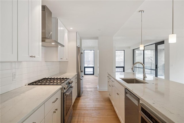 2330 Penn Ave Unit 302, Downtown Pgh, PA 15222 - kitchen with stainless steel appliances, wall chimney exhaust hood, a sink, backsplash, and light wood-style floors