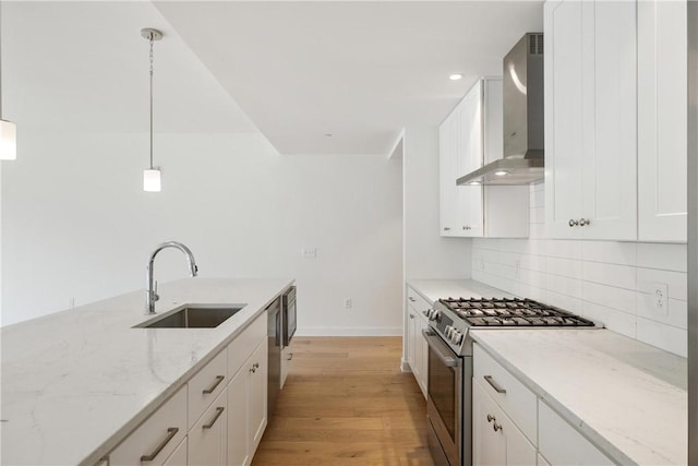 2330 Penn Ave Unit 302, Downtown Pgh, PA 15222 - kitchen featuring wall chimney exhaust hood, high end range, a sink, tasteful backsplash, and light wood-style flooring