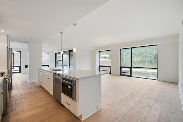 2330 Penn Ave Unit 302, Downtown Pgh, PA 15222 - kitchen featuring stainless steel appliances, light wood-style floors, a sink, a chandelier, and light countertops