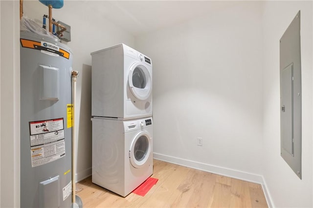 2330 Penn Ave Unit 302, Downtown Pgh, PA 15222 - washroom with stacked washer / dryer, electric water heater, light wood-type flooring, and baseboards