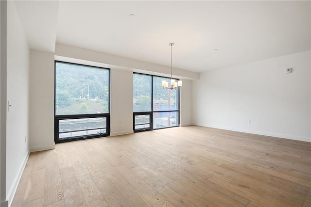 2330 Penn Ave Unit 302, Downtown Pgh, PA 15222 - unfurnished room with a chandelier, light wood-style flooring, and baseboards