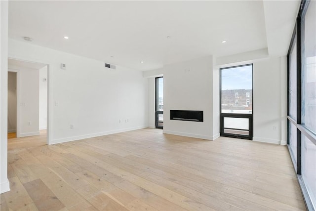 2330 Penn Ave Unit 302, Downtown Pgh, PA 15222 - unfurnished living room with light wood-type flooring, plenty of natural light, a fireplace, and recessed lighting