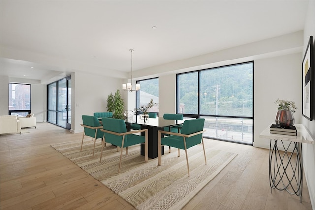 dining area with light hardwood / wood-style flooring and a chandelier