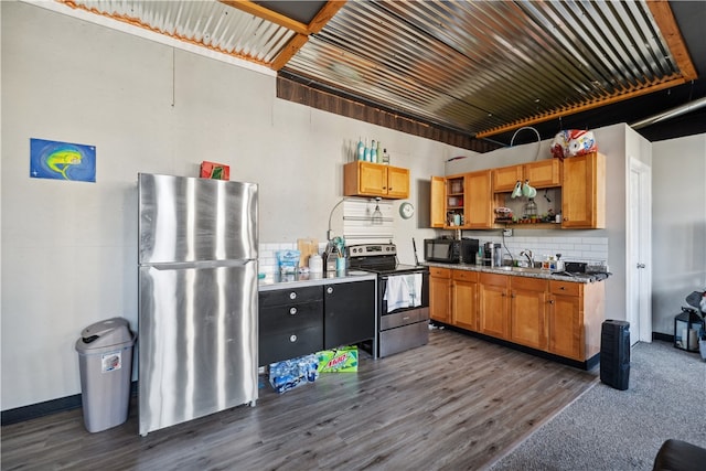 kitchen with appliances with stainless steel finishes, dark wood-type flooring, and decorative backsplash