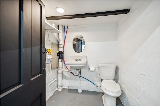 bathroom with concrete flooring and toilet