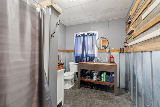 bathroom with sink, a paneled ceiling, and toilet