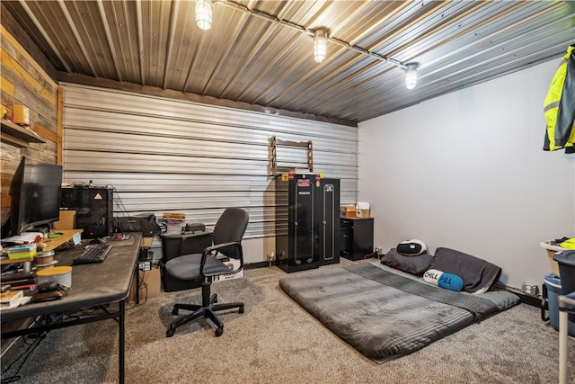 carpeted home office featuring wood walls