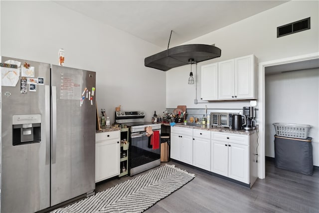 kitchen with appliances with stainless steel finishes, wood-type flooring, pendant lighting, and white cabinets