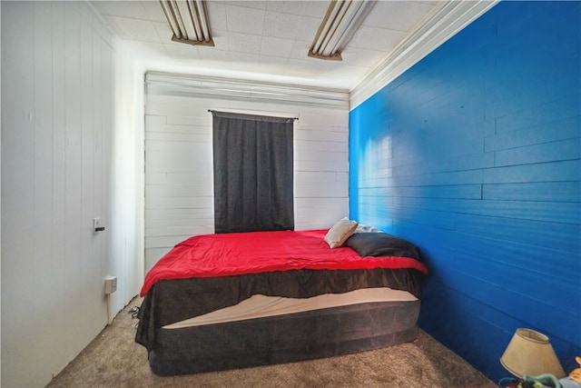 carpeted bedroom with wood walls and crown molding