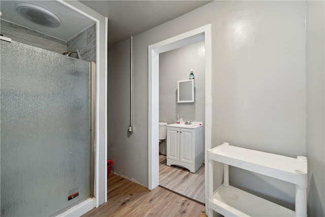 bathroom featuring hardwood / wood-style floors, walk in shower, and vanity