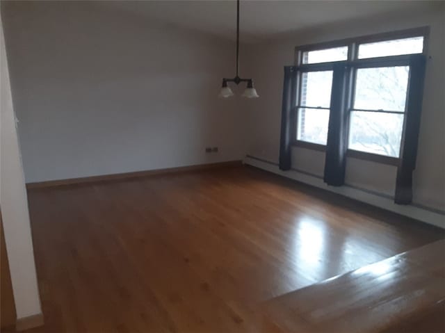 spare room featuring hardwood / wood-style floors and a baseboard radiator