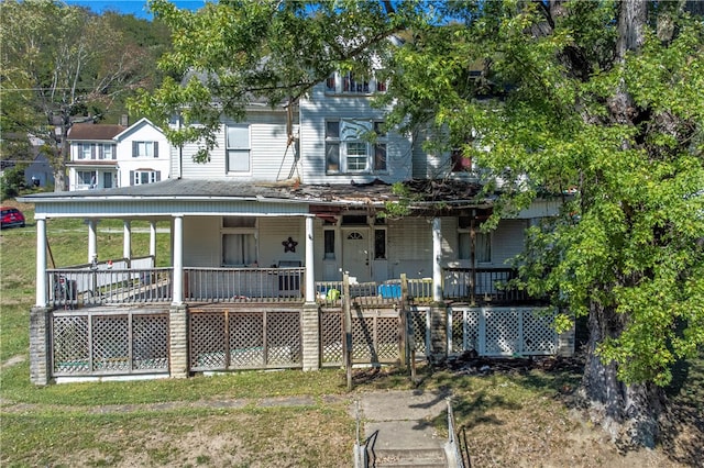 view of front of property with a deck and a front lawn