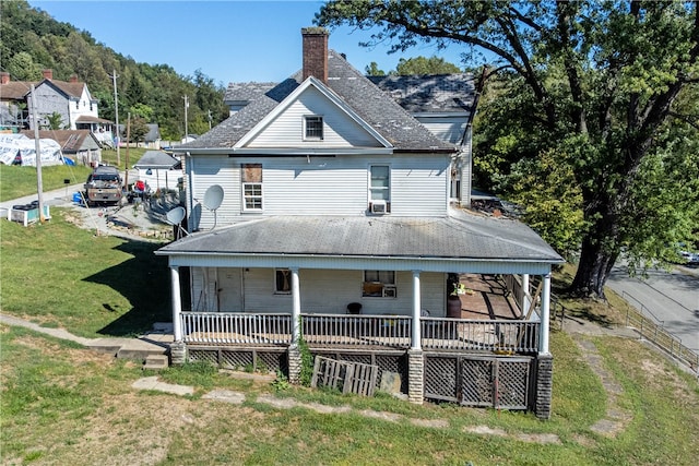 back of property featuring a porch and a lawn