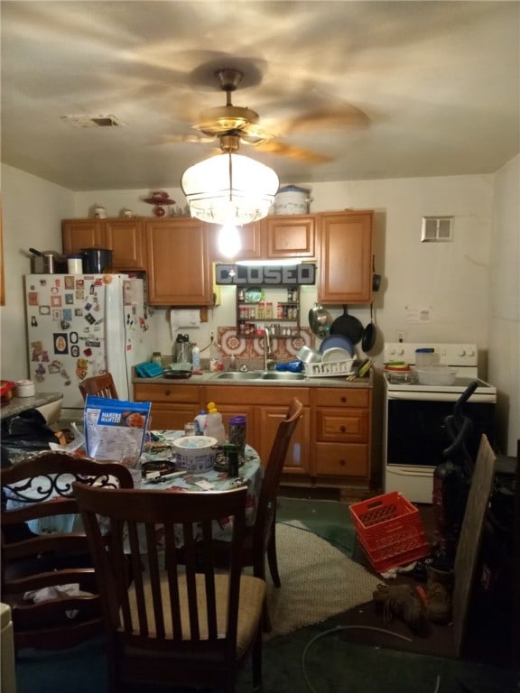 kitchen with white appliances, ceiling fan, and sink