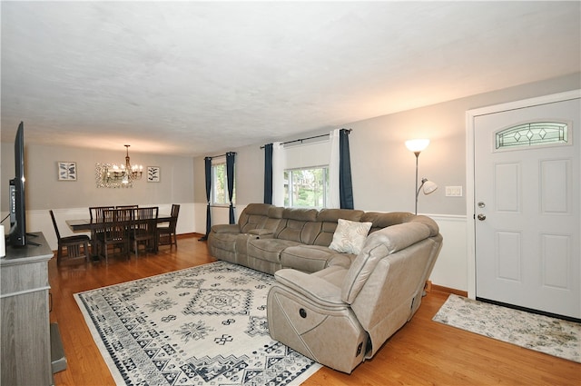 living room with wood-type flooring and an inviting chandelier