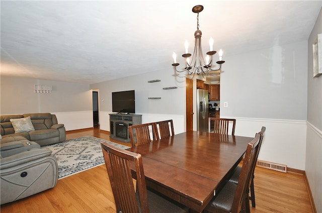 dining area featuring light hardwood / wood-style flooring and a chandelier