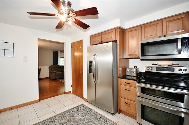 kitchen featuring ceiling fan, appliances with stainless steel finishes, and light tile patterned floors