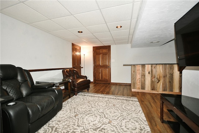 living room featuring a drop ceiling and dark hardwood / wood-style floors