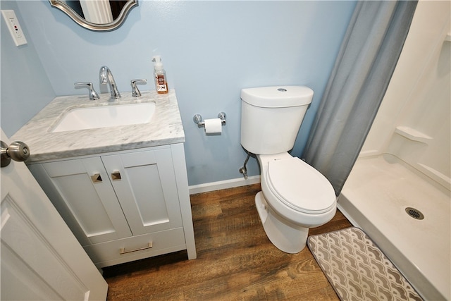 bathroom featuring vanity, a shower, hardwood / wood-style floors, and toilet