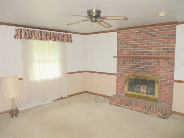 unfurnished living room with light carpet, ornamental molding, ceiling fan, and a fireplace