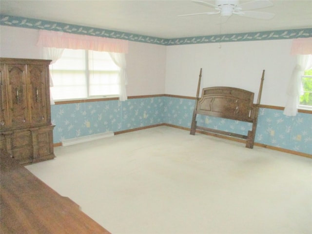 interior space featuring a baseboard radiator, ceiling fan, and carpet floors