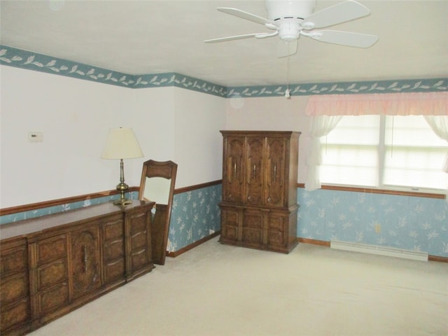 bedroom with ceiling fan, baseboard heating, and light carpet