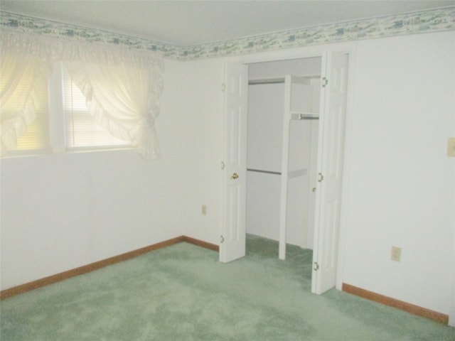 unfurnished bedroom with light colored carpet and a closet