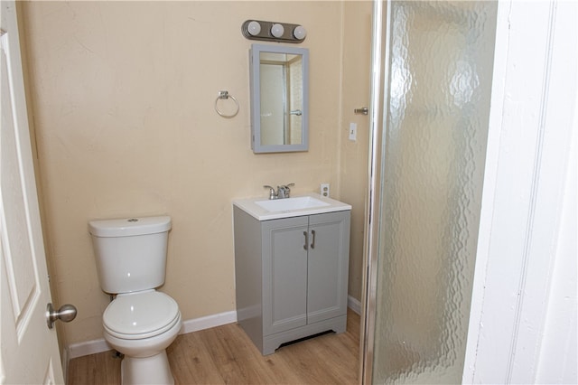 bathroom featuring vanity, hardwood / wood-style floors, and toilet