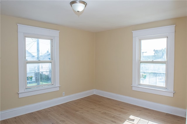 empty room featuring a healthy amount of sunlight and light hardwood / wood-style floors