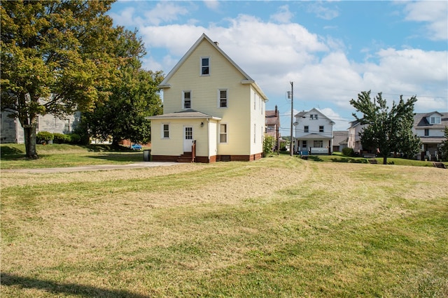 rear view of property featuring a yard