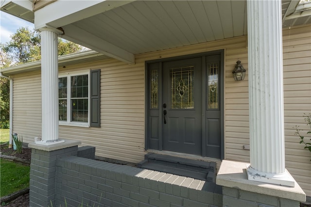 view of exterior entry featuring covered porch