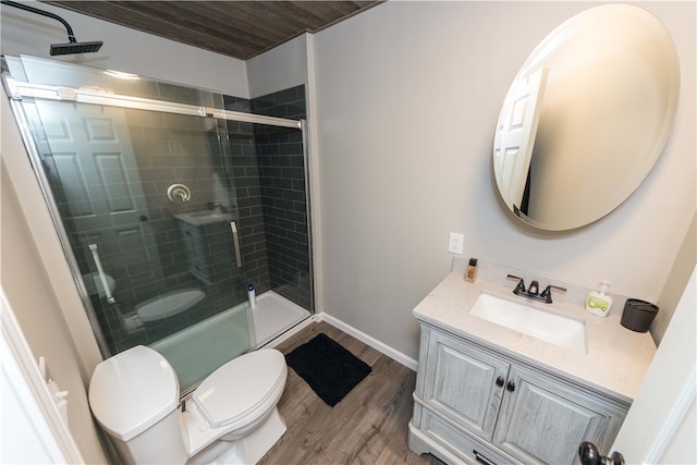 bathroom with walk in shower, vanity, hardwood / wood-style floors, and toilet