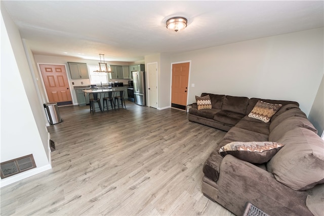 living room with light hardwood / wood-style flooring and sink