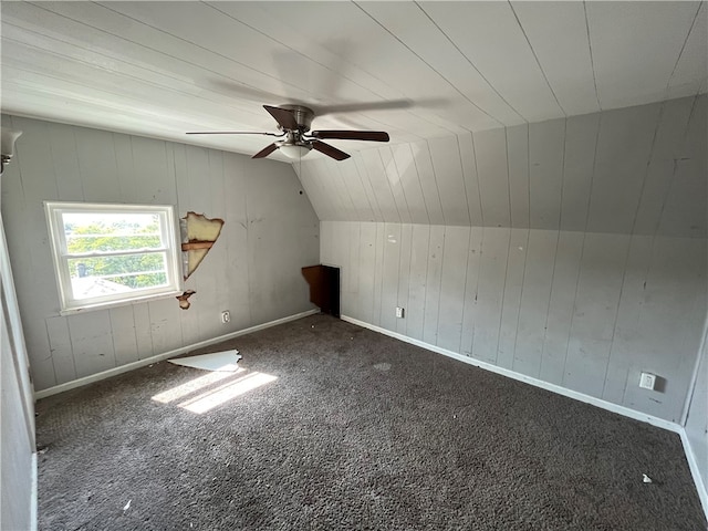 additional living space featuring ceiling fan, dark colored carpet, and vaulted ceiling