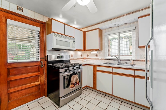 kitchen featuring white appliances, white cabinetry, sink, and plenty of natural light