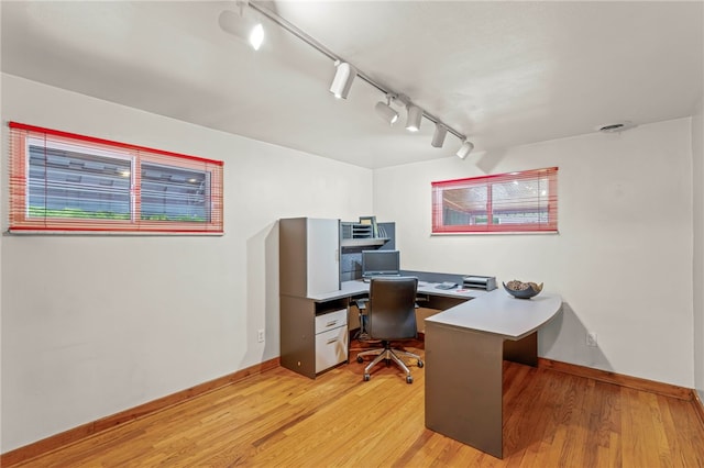 office featuring light hardwood / wood-style flooring and rail lighting