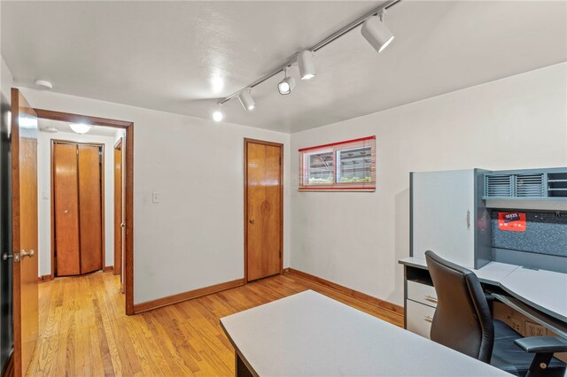 home office featuring track lighting and light hardwood / wood-style floors