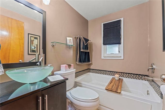 bathroom with vanity, a bathtub, and toilet