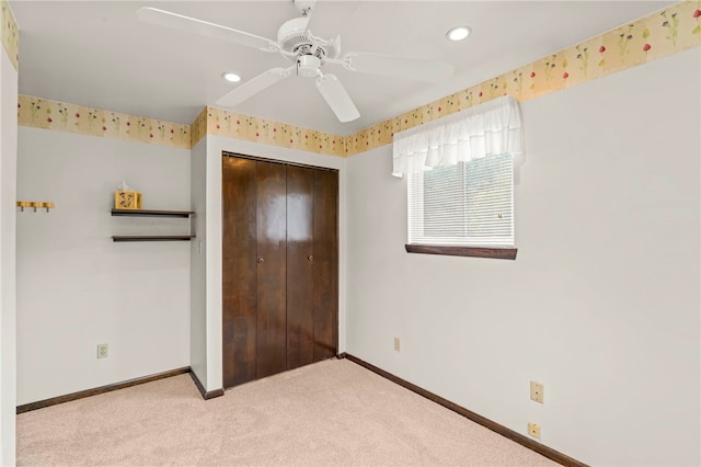 unfurnished bedroom featuring ceiling fan, a closet, and light carpet