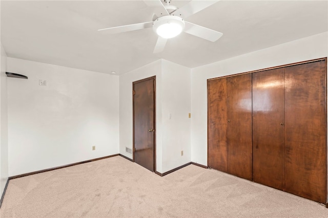 unfurnished bedroom featuring ceiling fan, a closet, and light carpet