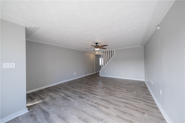 unfurnished living room featuring ceiling fan, a textured ceiling, light wood-type flooring, and ornamental molding