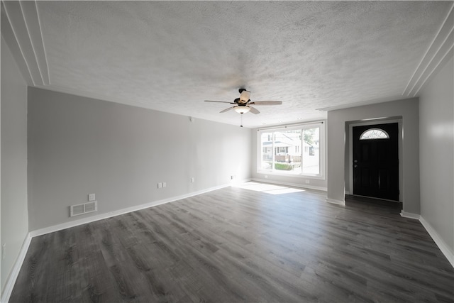 interior space with a textured ceiling, ceiling fan, and dark hardwood / wood-style flooring