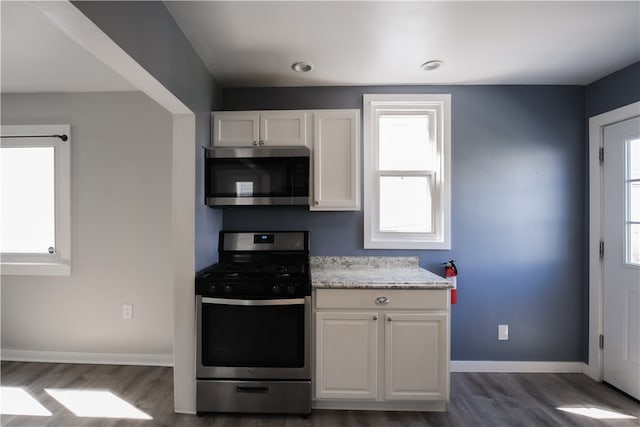 kitchen featuring white cabinets, appliances with stainless steel finishes, and dark hardwood / wood-style flooring