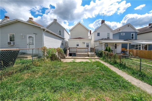 rear view of house featuring cooling unit, a wooden deck, and a yard