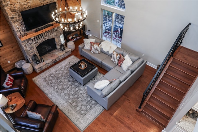 living room with a notable chandelier, a fireplace, and wood-type flooring